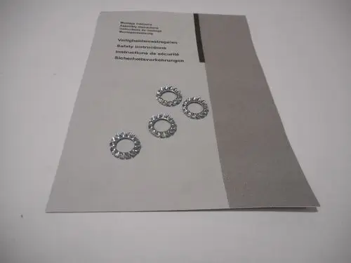 Bündel aus vier metallischen Zahnscheiben auf einer Anleitung. Die Anleitung enthält Sicherheitsinformationen von Remeha und Hinweise zur Montage.